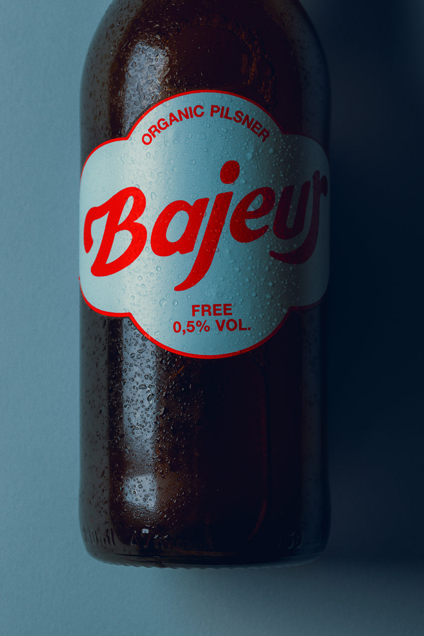 Wet bottle of Bajeur Free Organic Pilsner with a blue blackground