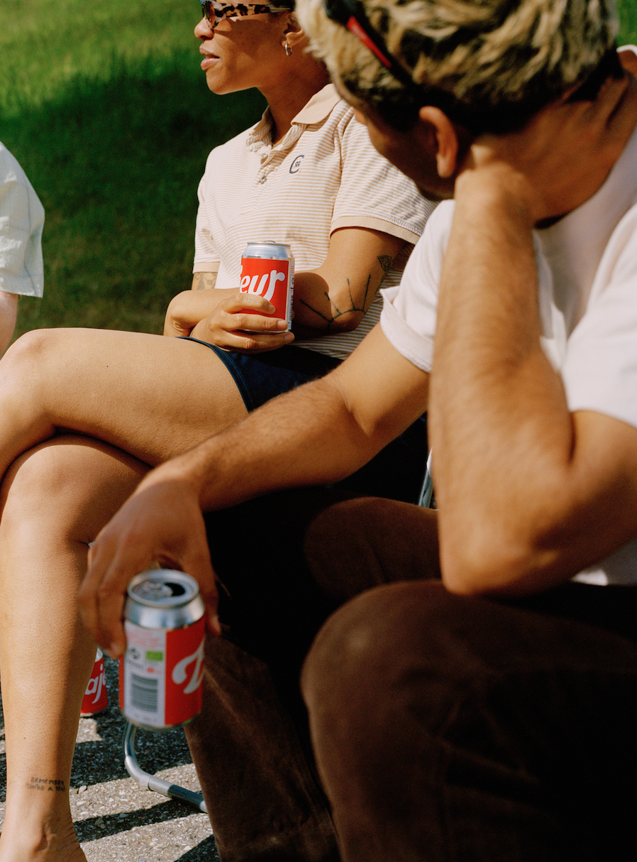 Two people holding Bajeur Easy Organic Pilsner cans 