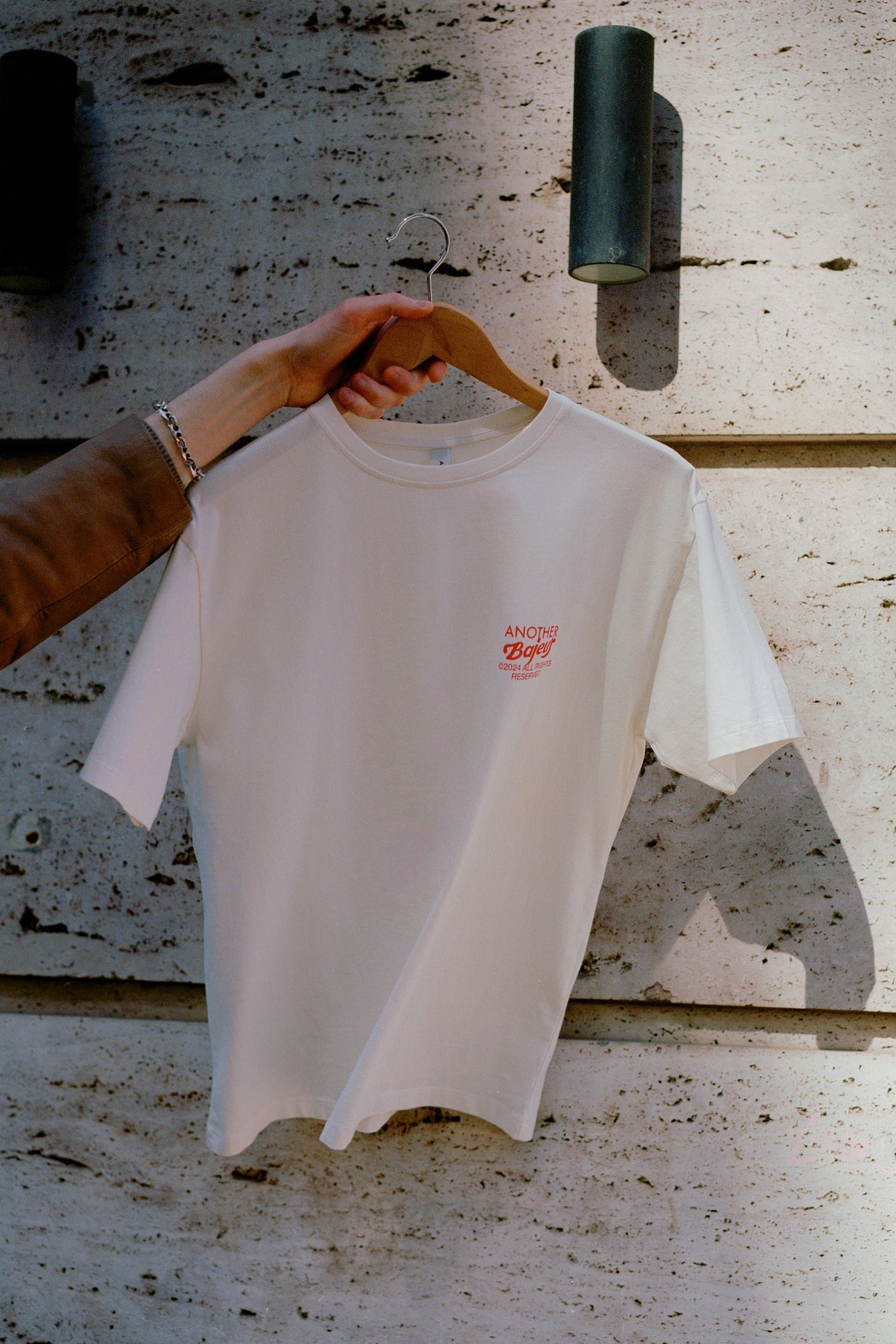 Cañas Club limited edition short-leev t-shirt. Beige with red logos and letters. This picture is from the front of the t-shirt.