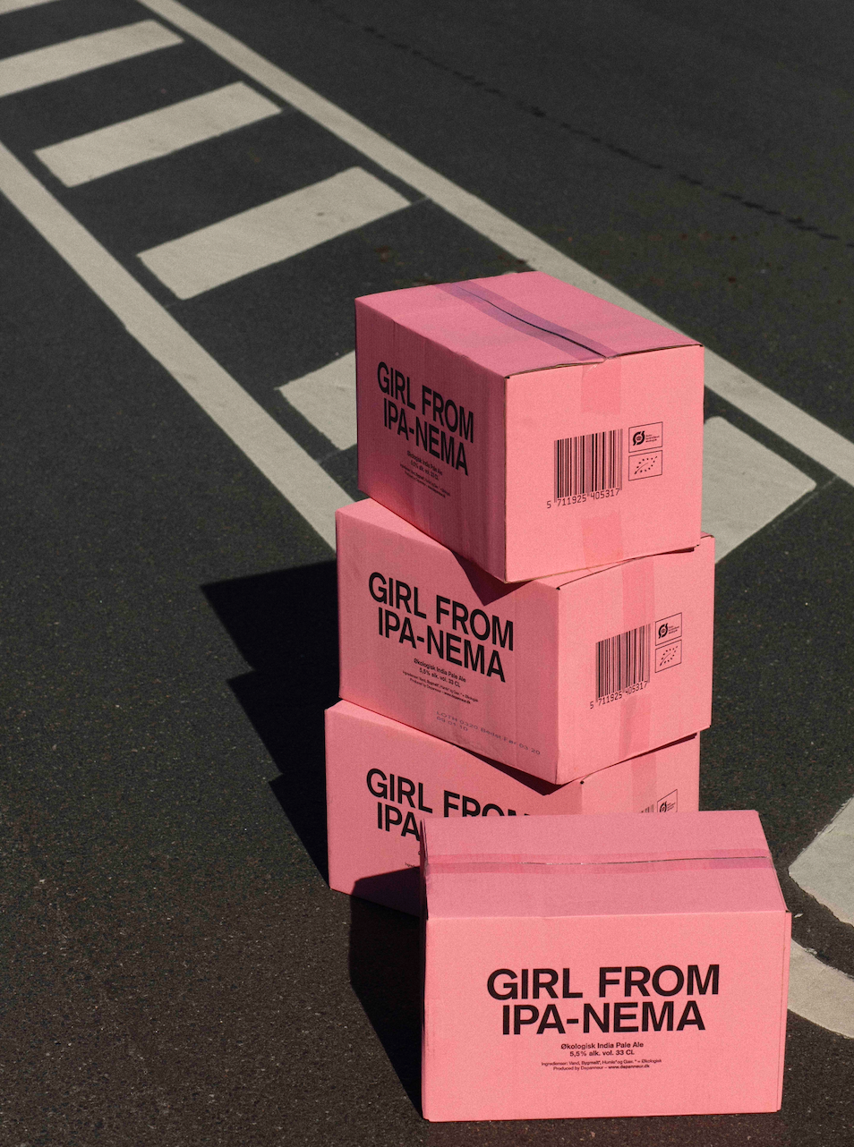 Stack of pink boxes with 'Girl From IPA-NEMA' organic Pale Ale on the road. 