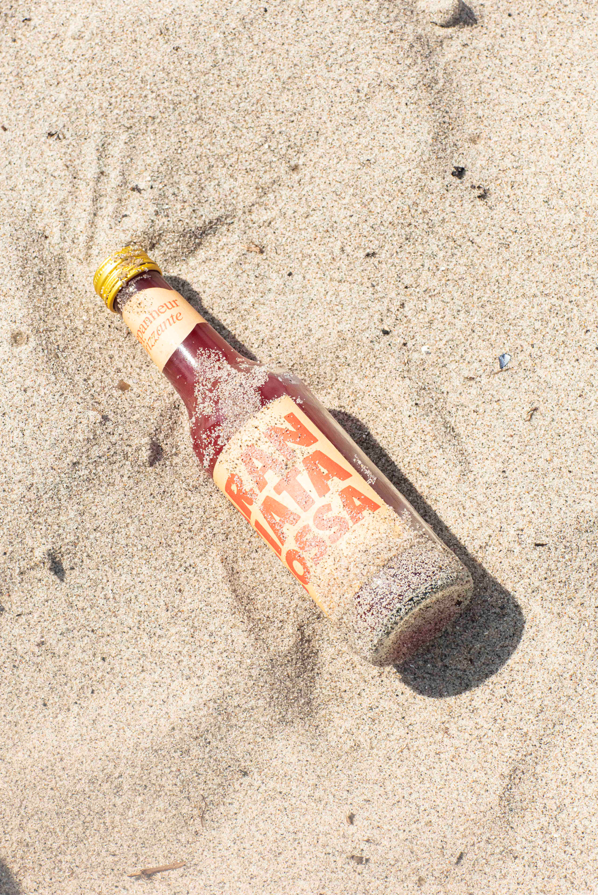 A sandy bottle of Arancata Rosso blood orange soda 